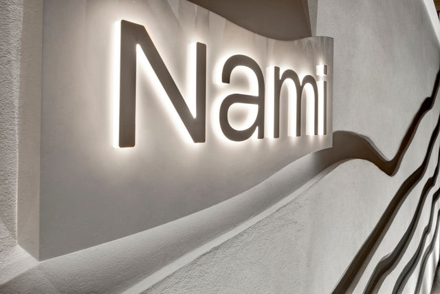 A close-up of a wall with a sign that says 'Nami'.