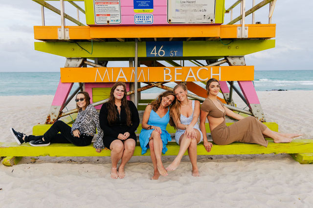Five people sitting on a lifeguard stand at the beach