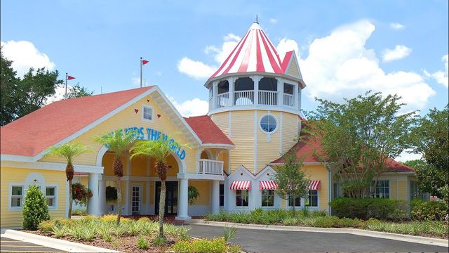 A yellow building with a red roof and a striped tower