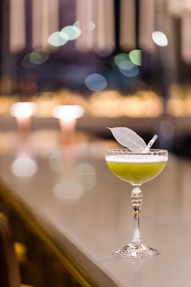 a cocktail with a leaf on top