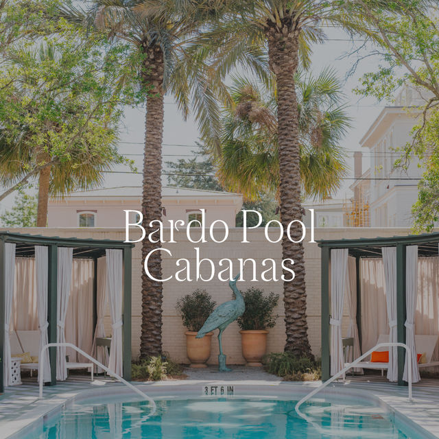 A poolside scene with cabanas, lounge chairs, and palm trees.