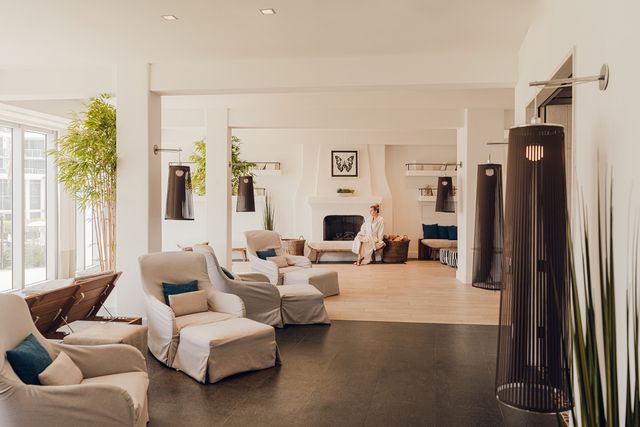 A serene lobby with a fireplace, comfortable seating, and large windows.